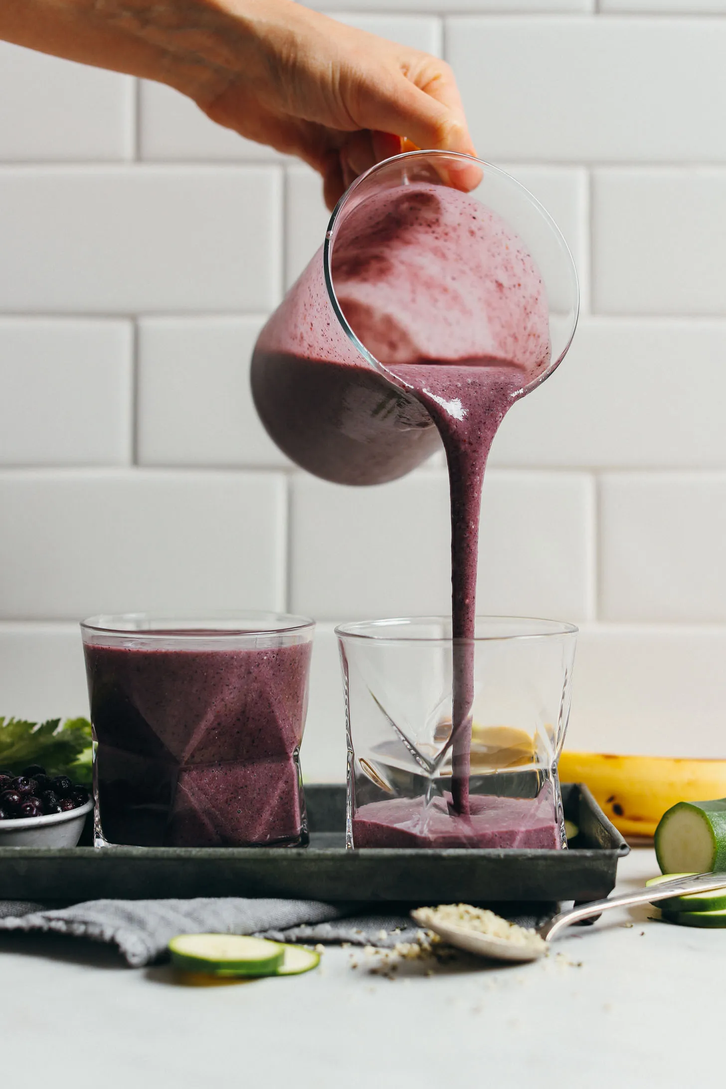 Pouring our healthy plant-based Zucchini Blueberry Smoothie into a glass